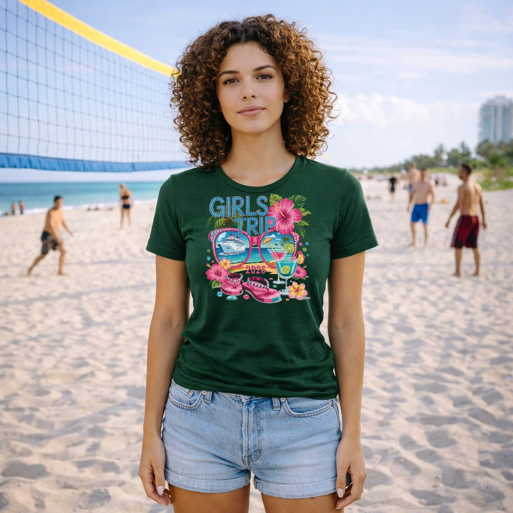 Woman wearing a green 'Girls Trip' t-shirt on a beach with people in the background.