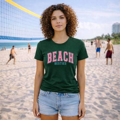 Woman wearing a green t-shirt with 'BEACH BESTIES' text on a beach.