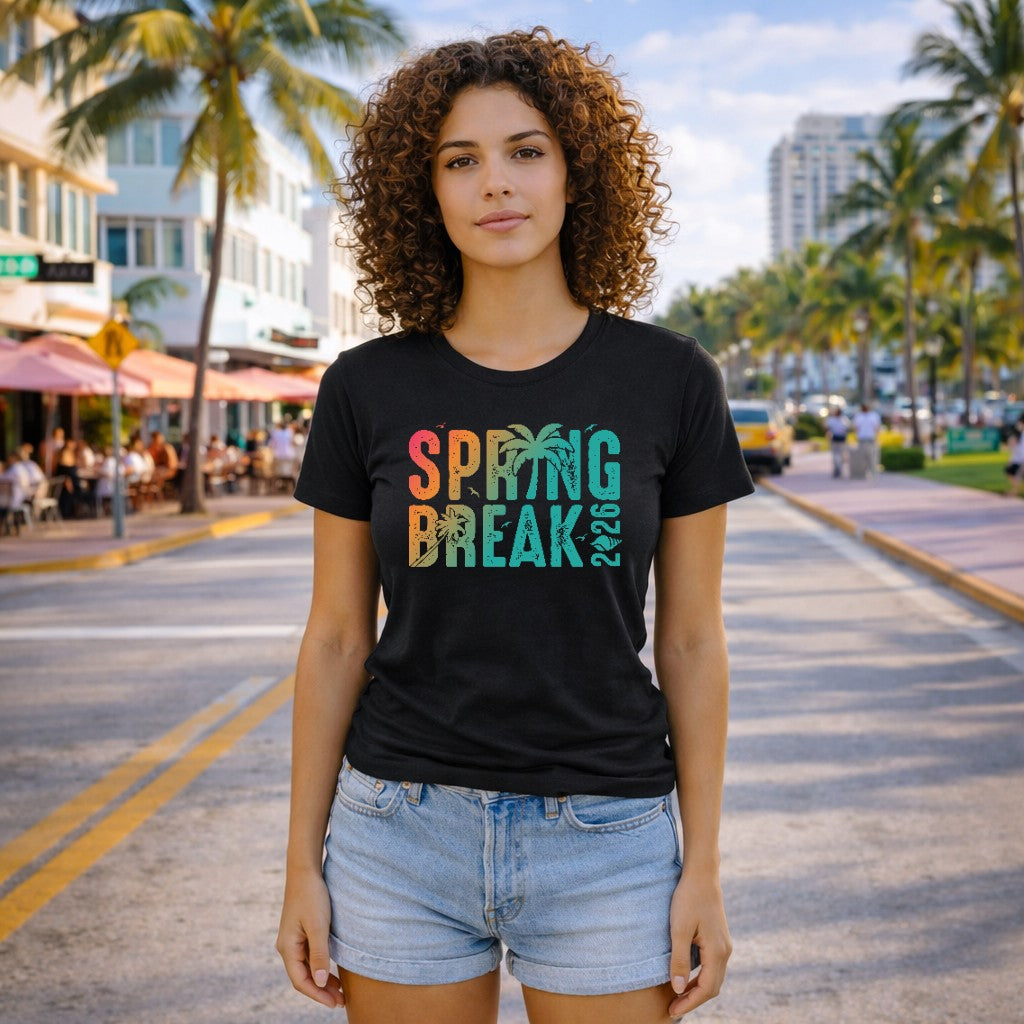 Woman wearing a black 'Spring Break 2026' t-shirt on a street with palm trees and buildings in the background.